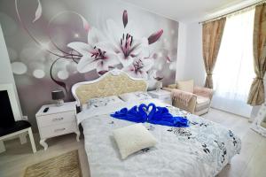 a bedroom with a bed with a large flower on the wall at White House & Jacuzzi in Sibiu