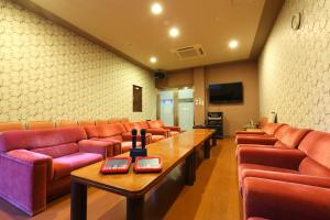 a waiting room with red leather couches and a table at Route Inn Grantia Dazaifu in Dazaifu