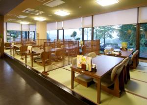 a restaurant with tables and chairs and large windows at Route Inn Grantia Dazaifu in Dazaifu