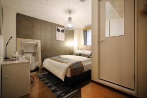 Habitación de hotel con cama y puerta a un dormitorio en SHINJUKU GLOBAL HOTEL en Tokio