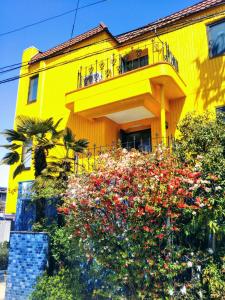 a yellow building with flowers in front of it at Hotel Unicorn in Nagano