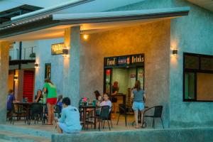 a group of people sitting at tables outside of a restaurant at Baan i Talay Chumphon บ้านไอทะเลชุมพร in Chumphon