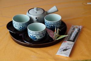 uma bandeja com três chávenas e um bule de chá sobre uma mesa em Pension Sonnenblume em Donnerskirchen