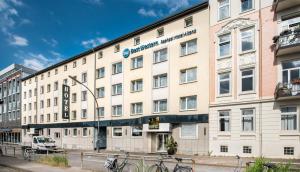 un grand bâtiment blanc avec des vélos garés devant. dans l'établissement Best Western Raphael Hotel Altona, à Hambourg