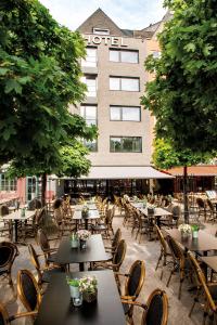 a row of tables and chairs in front of a hotel at Prevôt Restaurant & Hotel in Cologne