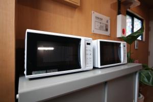 東京にあるSHINJUKU GLOBAL HOTELの2台の電子レンジがカウンターに座っている +37枚の写真