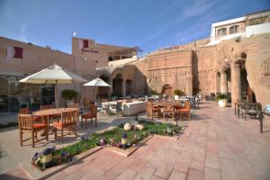 an outdoor patio with tables and chairs and an amphitheater at Petra Guest House Hotel in Petra