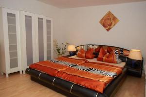 ein Schlafzimmer mit einem großen Bett mit orangefarbenen Decken und Kissen in der Unterkunft Ferienwohnung für 4 Personen in Sassnitz in Sassnitz
