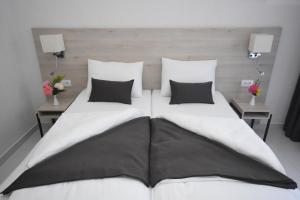 een groot wit bed met 2 kussens erop bij Hotel Mladost in Tjentište