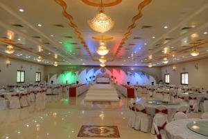 a large banquet hall with white tables and chairs at Khasab Hotel in Khasab