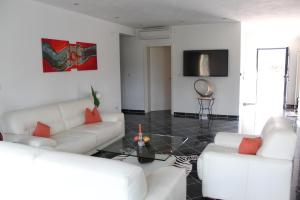 a living room with two white couches and a tv at Villa Antunovic in Malinska