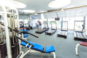 a gym with treadmills and machines in it at The Maruay Garden Hotel in Bangkok