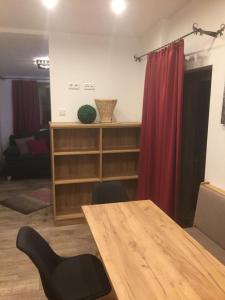 烏騰多夫的住宿－海濱公寓，配有木桌和红色窗帘的房间