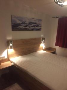 a bedroom with a large bed with lights on it at Apartment Haus am See in Uttendorf