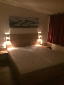 a bedroom with a large bed with lights on it at Apartment Haus am See in Uttendorf