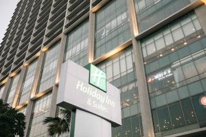 a building with a hilton sign in front of it at Holiday Inn & Suites Jakarta Gajah Mada, an IHG Hotel in Jakarta