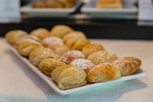 - un plateau de beignets et de pâtisseries sur une table dans l'établissement Culture Hotel Villa Capodimonte, à Naples