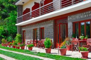 a building with tables and chairs and potted plants at Elatou in Ano Chora