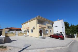a building with a red car parked in a parking lot at Studio Emanuel in Rovinj