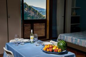 un tavolo con una tovaglia blu e un piatto di frutta di Piccolo Sole d'oro - appartamenti a Calatafimi