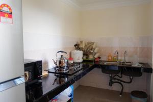 Permai Seri Homestay في أمبانغ: مطبخ صغير مع موقد ومغسلة