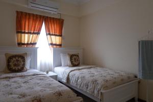 a bedroom with two beds and a window at Permai Seri Homestay in Ampang