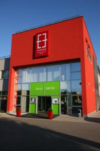 a red building with a hospital ever life sign on it at Hotel EMPIRE in Trnava