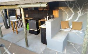 a kitchen with two chairs and a stove at Off Beat Safaris Bush Lodge in Hoedspruit