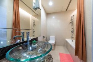 八打灵再也Suite @ Sunway Pyramid Mall的一间带玻璃水槽和卫生间的浴室