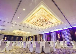 a banquet hall with white chairs and a chandelier at Best Western Premier Tuushin Hotel in Ulaanbaatar