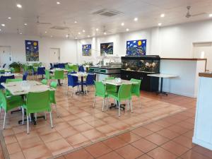 Un comedor con mesas y sillas y una cocina. en Magnetic Island Resort, Sleeps 3, Free WIFI, en Nelly Bay