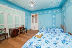 Schlafzimmer mit blauen Wänden, einem Bett und einem Schreibtisch in der Unterkunft Nukri Guest House in Gori