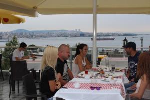 un gruppo di persone sedute a un tavolo che mangiano di Ararat Hotel a Istanbul