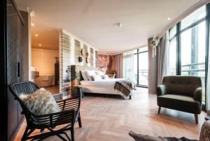 a bedroom with a bed and a couch and a chair at Van der Valk Theaterhotel Almelo in Almelo