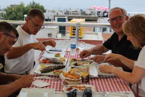 un grupo de personas sentadas alrededor de una mesa comiendo comida en Ararat Hotel, en Estambul