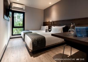 ein Hotelzimmer mit Bett und Schreibtisch in der Unterkunft Meridian Adventure Marina Club & Resort in Saonek + 166 Fotos