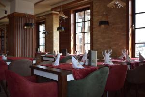 a row of tables in a restaurant with red chairs at Hotel Zlatni Bor in Sokolac