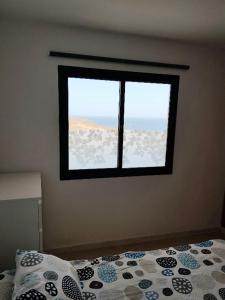 ein Schlafzimmer mit einem Bett und einem Fenster in der Unterkunft Superbe appartement à Costa Antigua in Costa de Antigua + 12 Fotos