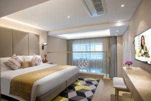 a bedroom with a large bed and a window at Citadines Keqiao Shaoxing in Shaoxing