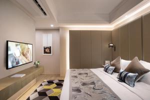 a bedroom with a large bed and a television at Citadines Keqiao Shaoxing in Shaoxing