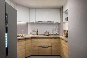 a kitchen with white cabinets and a sink at Citadines Keqiao Shaoxing in Shaoxing