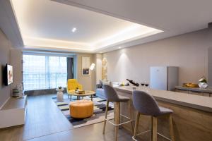 a kitchen and living room with a table and chairs at Citadines Keqiao Shaoxing in Shaoxing