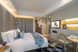 a hotel room with a large bed and a table at Citadines Keqiao Shaoxing in Shaoxing
