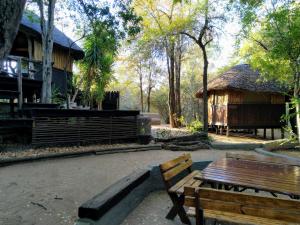 a park with a wooden bench and a building at Off Beat Safaris Bush Lodge in Hoedspruit