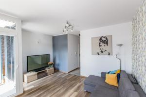 a living room with a couch and a flat screen tv at Star4You Apartments in Wrocław