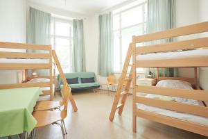 a bedroom with bunk beds and a room with a bed at Hostel Mikoláše Alše in Prague