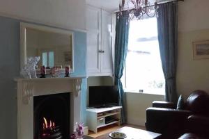 a living room with a fireplace and a television at Dales View House in Barnoldswick