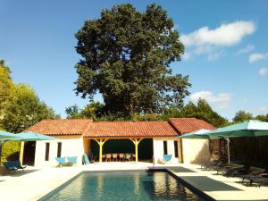 una casa con piscina con sillas y sombrillas en Les Bernardies en Simeyrols