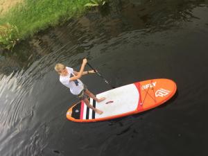 a person is standing on a surfboard in the water at Ferienwohnung an der historischen Stadtmauer in Rostock