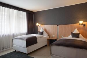 a bedroom with two beds and a large window at Hotel Asahi in Düsseldorf +67 photos